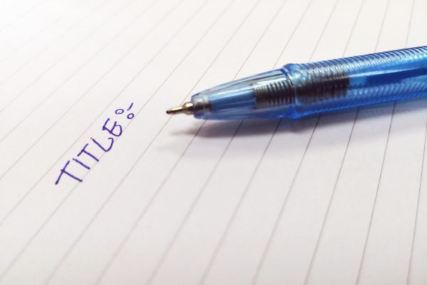 ノートに文字を書く、ペン、青ペン、TITLE、タイトル、ノートにタイトルと書かれた文字、