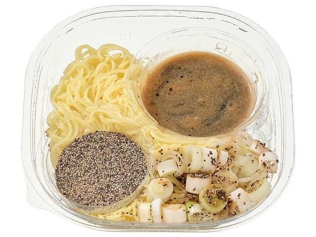 ねぎを盛り付けた黒いスープの「冷やしコショウそば」と、別添えのあらびきコショウ