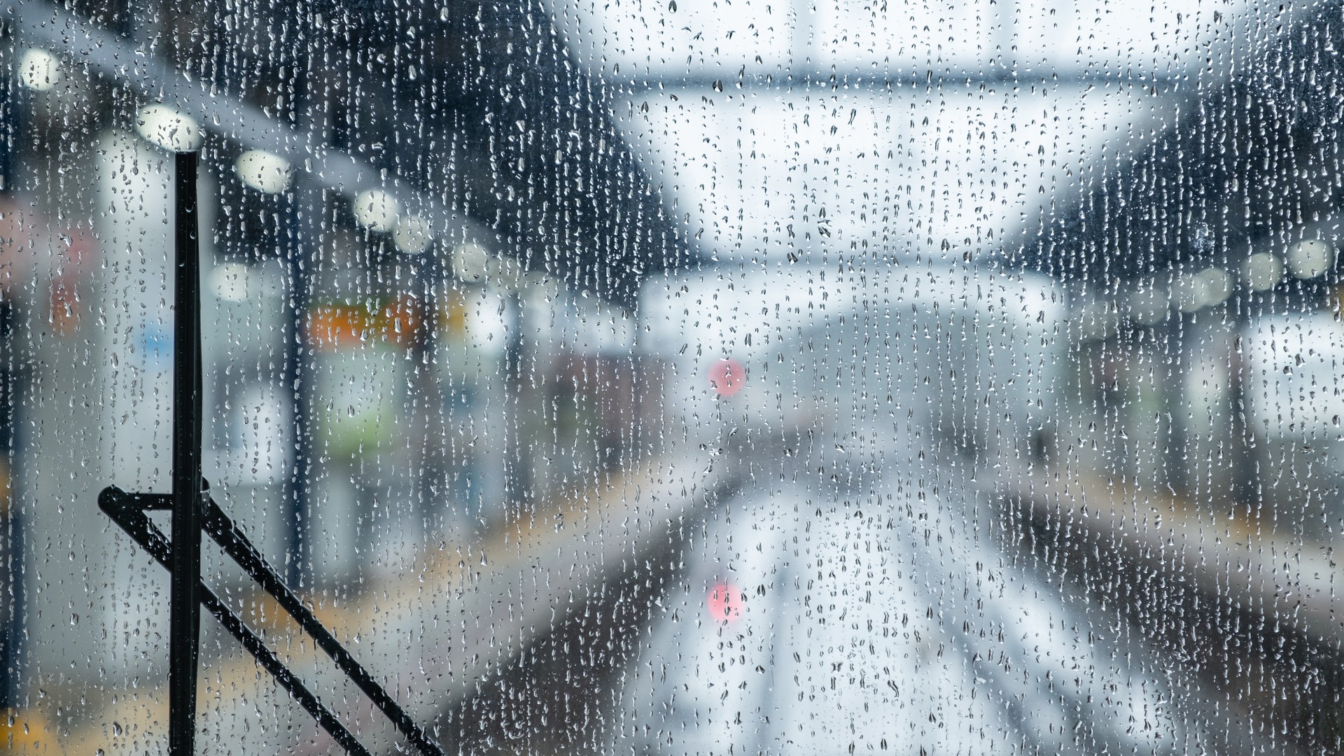 電車の窓ガラスに付いた雨粒越しに、ぼやけて見える駅のホーム