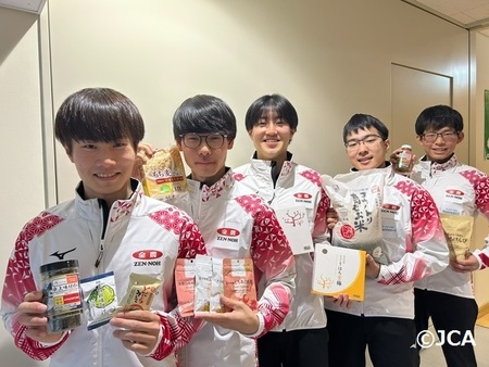 「ニッポンの食」を手に笑顔のカーリングジュニア日本代表チームの皆さん